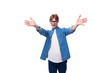 young joyful surprised red-haired guy dressed in a blue shirt wears glasses on a white background with copy space