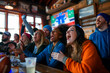 A group of American football fans gathered at a bar, watching a live match and enjoying drinks.