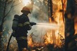 A firefighter in action, spraying water on a raging forest fire to extinguish flames and prevent further spread.