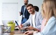 © opolja - Happy group of businesspeople during presentation. Businessman looking at camera and smiling