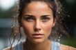 Close up portrait of woman in the rain. Female athlete with sweat droplets on her face. Sporty woman doing exercises outdoor