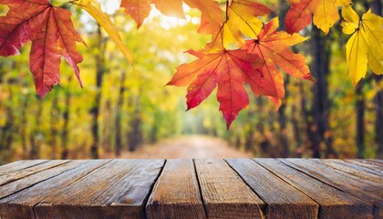 Wall Mural - wooden table and blurred autumn background autumn concept with red yellow leaves background