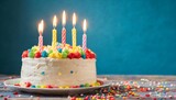 Fototapeta Tęcza - birthday cake with candles on blue background with copy space created with