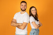 © Prostock-studio - Smiling confident man and woman in white t-shirts with arms crossed, standing side by side