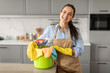© Prostock-studio - Happy woman with cleaning supplies in bucket