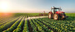 © ADDICTIVE STOCK - Tractor spraying crops at sunset on a vast farm field. Generative AI image