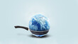 © alones - Planet earth burns in a frying pan on a gas burner on a blue background, concept. Global warming and climate change, creative idea. Save planet earth