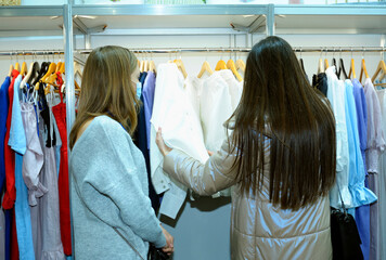 Shopping. Two women buyers choosing clothes at the boutique