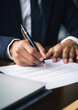 © Julia Zarubina - signing an agreement, a man in a business suit writes with a pen on paper, hands, office, table, contract, documents, signature, work, finance, taxes, accounting