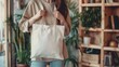 © wpw - A woman holds a canvas fabric bag for a mockup blank template, suitable for customization and design purposes.