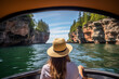 Woman enjoying a scenic boat tour of sea caves under a clear blue sky