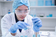© Supapich - Woman research scientist biology chemistry medicine pouring liquid from beaker to test tube indoor science laboratory room, adult female person blue glove work discovery experiment medical chemist