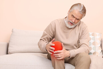 Wall Mural - Man suffering from rheumatism in knee at home. Space for text