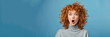 © Nataliia_Trushchenko - Portrait of surprised curly woman biting her lips and looking with wide open eyes with a curious expression, wearing a casual gray jumper, isolated on blue background. Human facial expression concept