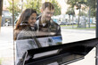 © Maskot - Happy young couple looking at placard on glass window of real estate office