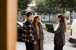 © Maskot - Smiling saleswoman talking with couple while standing at street