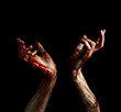 Creepy hands of undead with dripping blood over black background