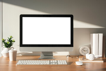 Wall Mural - Front view blank computer desktop  and office supplies on wooden table. Empty screen for advertising.