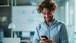© HelenP - Happy man using a smartphone during his work in the office