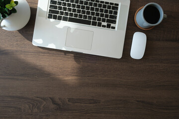 Wall Mural - Modern workplace with laptop computer, coffee cup and pencils on wooden background. Top view.