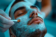Man applying a facial mask in a beauty salon.