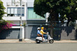 © DragonImages - Woman using motorbike taxi service to get to office
