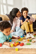 © LIGHTFIELD STUDIOS - focus on jolly african american mother and her son next to her other blurred son playing with toys