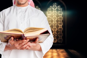 Wall Mural - A man holding big holy Quran book in hands