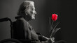 An elderly woman with Parkinson's disease and red tulip in his hands in wheelchair