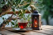 a lantern with a burning candle and a glass of tea on a plate. Ramadhan Kareem greeting card invitation.