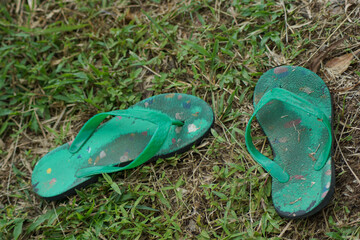 worn flip flops left on the grass