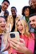 © CarlosBarquero - Vertical photo. A group of happy amazed humans friends in outerwear using mobile smiling watching something funny and surprising on their cell phones. They are sharing a joyful moment through gestures