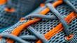 Laced up gray mesh fabric sneakers macro shot. Laced fastening of new orange sole sport shoe close-up. Elastic laces of modern textile trainers for active lifestyle, sport and fitness. Copy space.