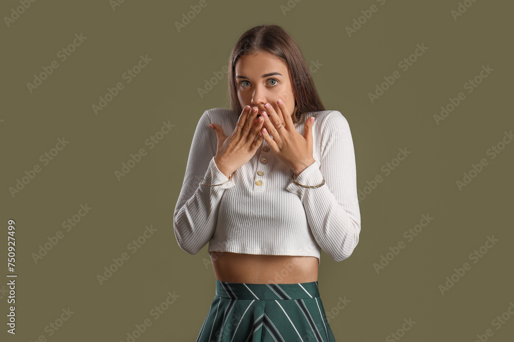 Scared young woman on green background