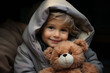 A child with a beaming smile, snug in a hooded coat, clutches a teddy bear, suggesting eco-friendly and handmade toys. themes of innocence, comfort, and sustainable childhood play.