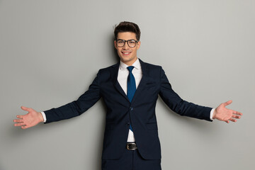 Wall Mural - young businessman making welcoming hand gesture