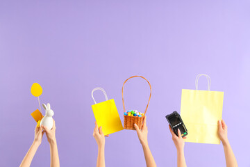 Poster - Women with payment terminal, bags and Easter decor on lilac background. Online shopping