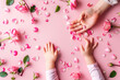 Top view layout of mother hand and little daughter hand surrounded by rose petals over pink backgorund. Mother's day conceptual banner for promotion