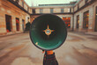 Person holding a green megaphone against a blurred urban background, concept of voice and protest in public space.