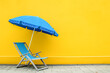 Chair and beach hat and yellow wall background, with vibrant colors that highlight the colors and textures characteristic of summer