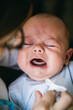 © Inuk Studio/Stocksy - Parent comforting screaming annoyed newborn baby