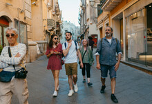 Group of tourists walking on the streets of small touristic town