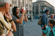 © Jimena Roquero/Stocksy - Group of tourists taking pictures and talking in old Italian town