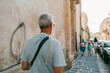 © Jimena Roquero/Stocksy - People walking on the sidewalk of an old Italian City.