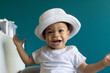 © Anna Berkut/Stocksy - surprise, happy one year old baby portrait in hat, fashion child boy