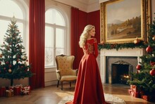 Woman In Beautiful Red Dress Standing Near Vintage Fireplace And Christmas Tree, Victorian Style Home Decor With Large Framed Painting And Christmas Decorations, Red Curtains. 