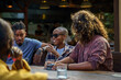 © Jovo Jovanovic/Stocksy - Friends talking at restaurant