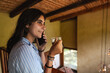 © Luis Herrera/Stocksy - woman on the phone drinking coffee