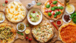 © Pietro Karras/Stocksy - Table in cafe full of fresh pizzas