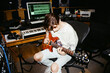 © Anastasia Vorobeva/Stocksy - adult man playing guitar in recording room